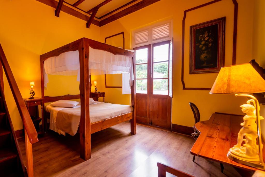 Quarto da Pousada Imperial Koeler em Petrópolis com cama com dossel e decoração clássica