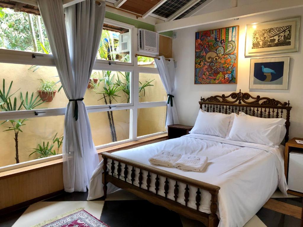 Quarto da Pousada Vale Valparaíso Inn em Petrópolis com cama de casal e parede escura decorada