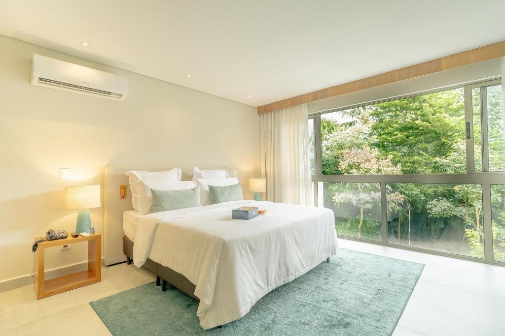Quarto da Île de Pipa em Pipa com cama de casal e janela ampla com vista para área verde