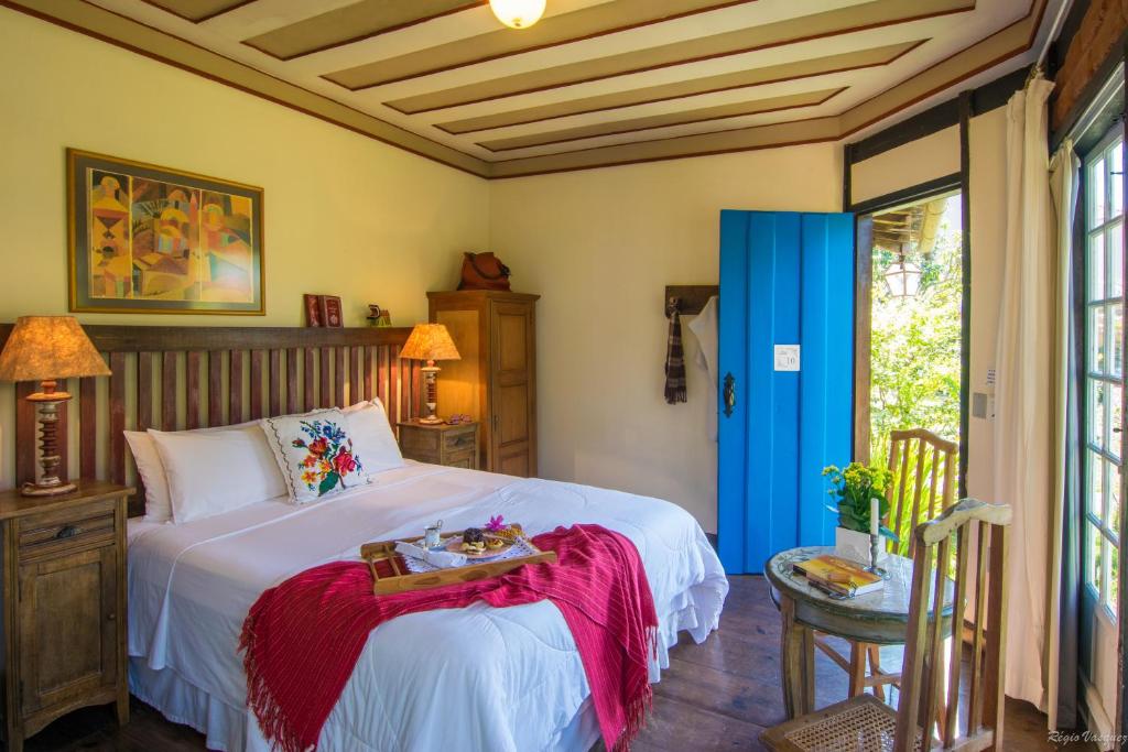 Quarto da Pousada Paço do Lavradio em São João del Rei com decoração rústica e porta azul