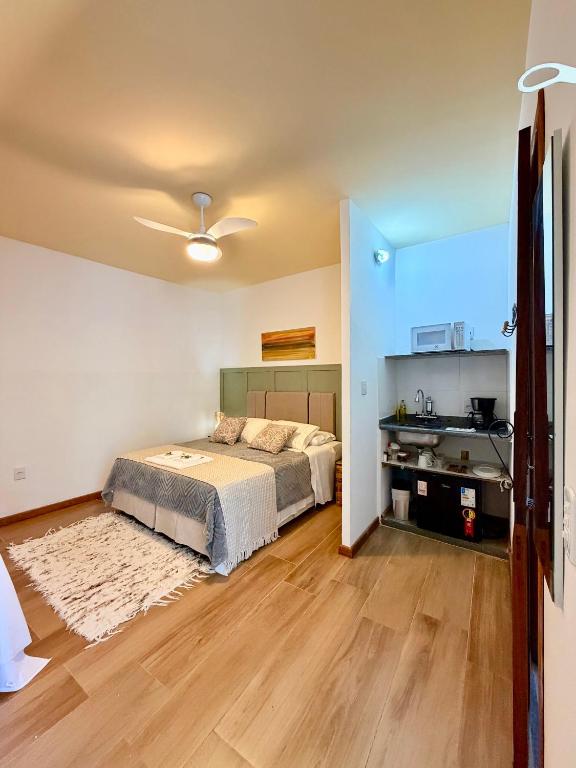 Quarto do Villa Barroca Lofts em São João del Rei com cama de casal e cozinha compacta integrada