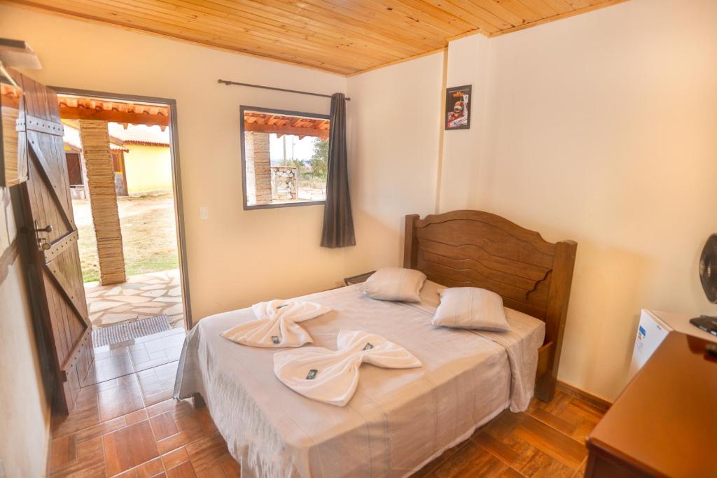 Quarto da Pousada e Chalés Pôr do Sol em São Thomé das Letras com cama de casal e porta para área externa