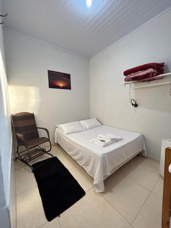 Quarto da Pousada Maciel em São Thomé das Letras com cama de casal e cadeira de madeira