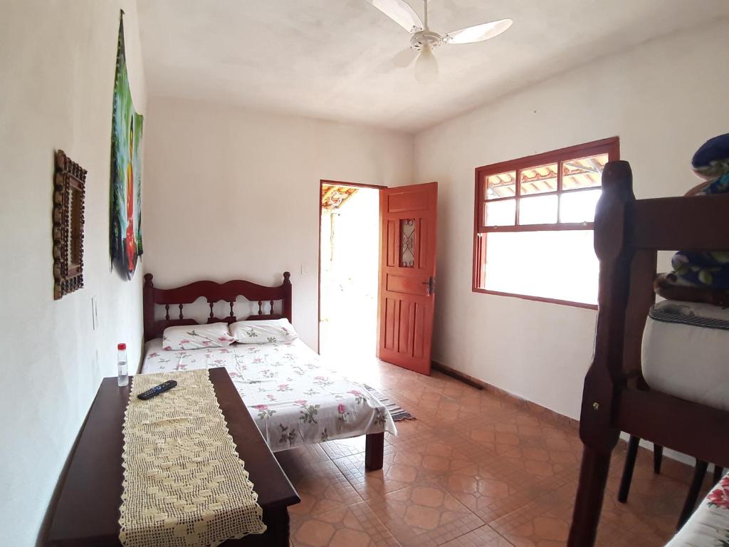 Quarto da Pousada Natureza em São Thomé das Letras com cama de casal e porta aberta para área externa