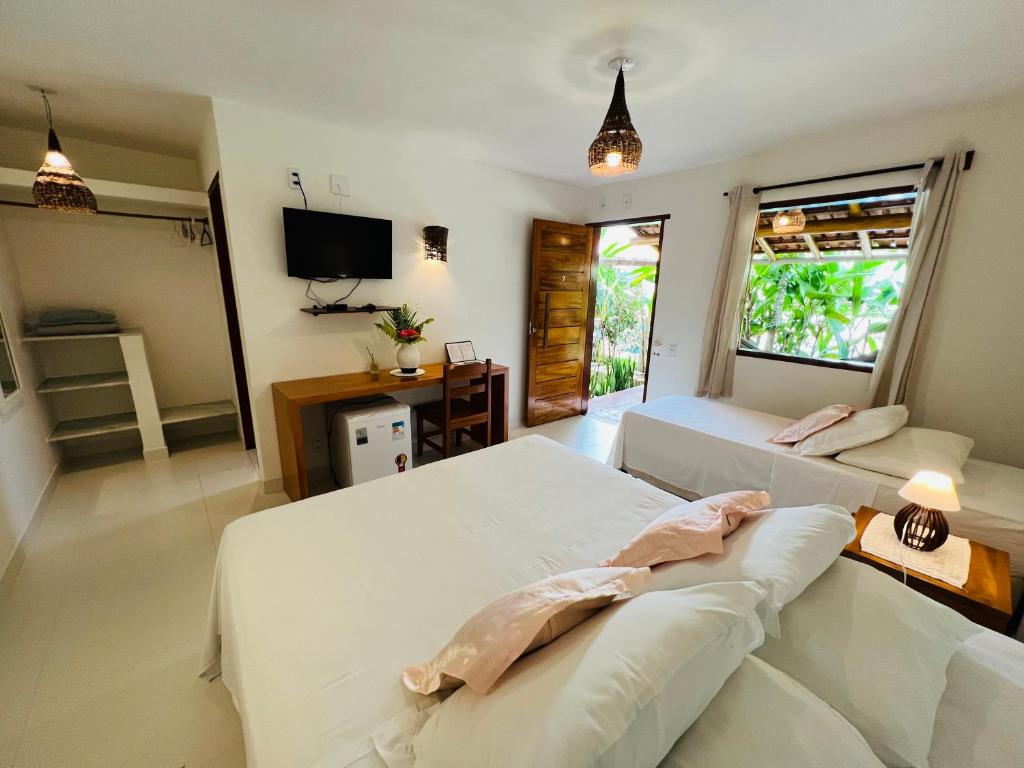 Quarto da Pousada Pandoro em Trancoso com duas camas de solteiro e porta aberta para área externa