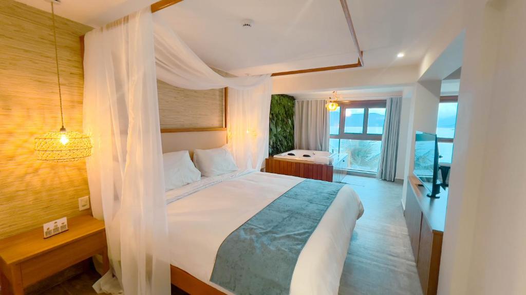Quarto do Catalina Hotel em Ubatuba com cama de casal, hidromassagem e vista para o mar
