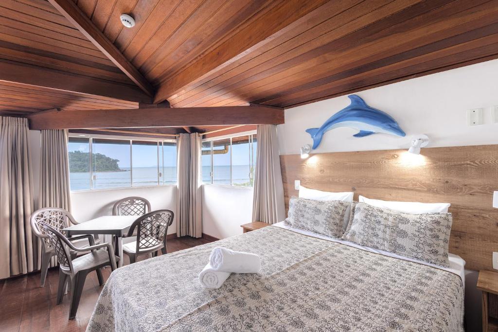 Quarto da Kaliman Pousada em Ubatuba com cama de casal e janelas com vista para o mar