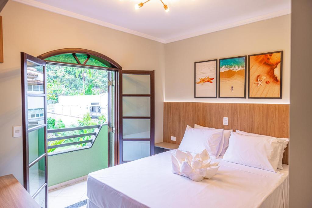 Quarto do Ubatuba Eco Hotel em Ubatuba com cama de casal e porta aberta para varanda