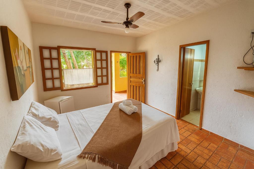 Quarto da Pousada Bella Vista na Serra do Cipó com cama de casal, porta aberta e acesso ao exterior