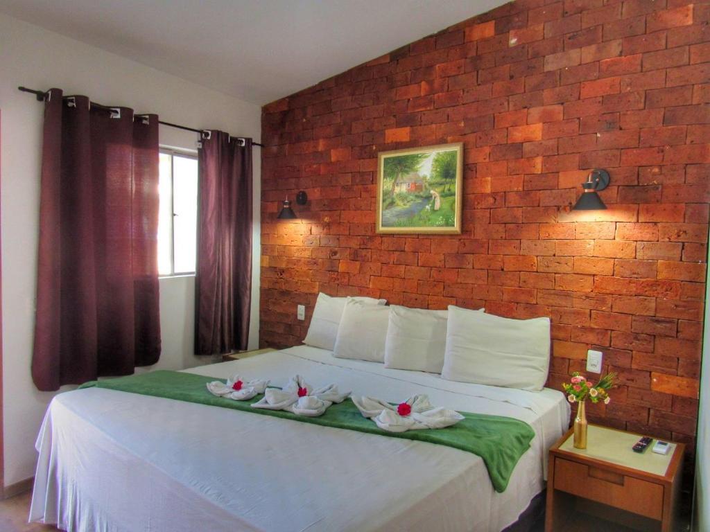 Quarto da Pousada SR Ivan na Serra do Cipó com cama de casal e parede de tijolos aparentes