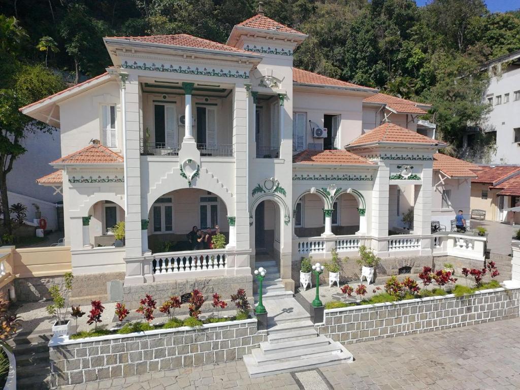 Fachada da Casa das Luzes Hostel IVN no Rio de Janeiro com arquitetura clássica e jardim frontal