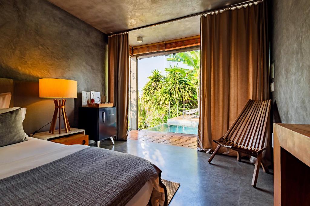 Quarto da Casa Gerânio no Rio de Janeiro com varanda e piscina privativa cercada por vegetação