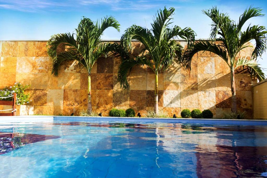 Piscina do Majestic Ponta Negra Beach em Natal com água azul e palmeiras ao fundo