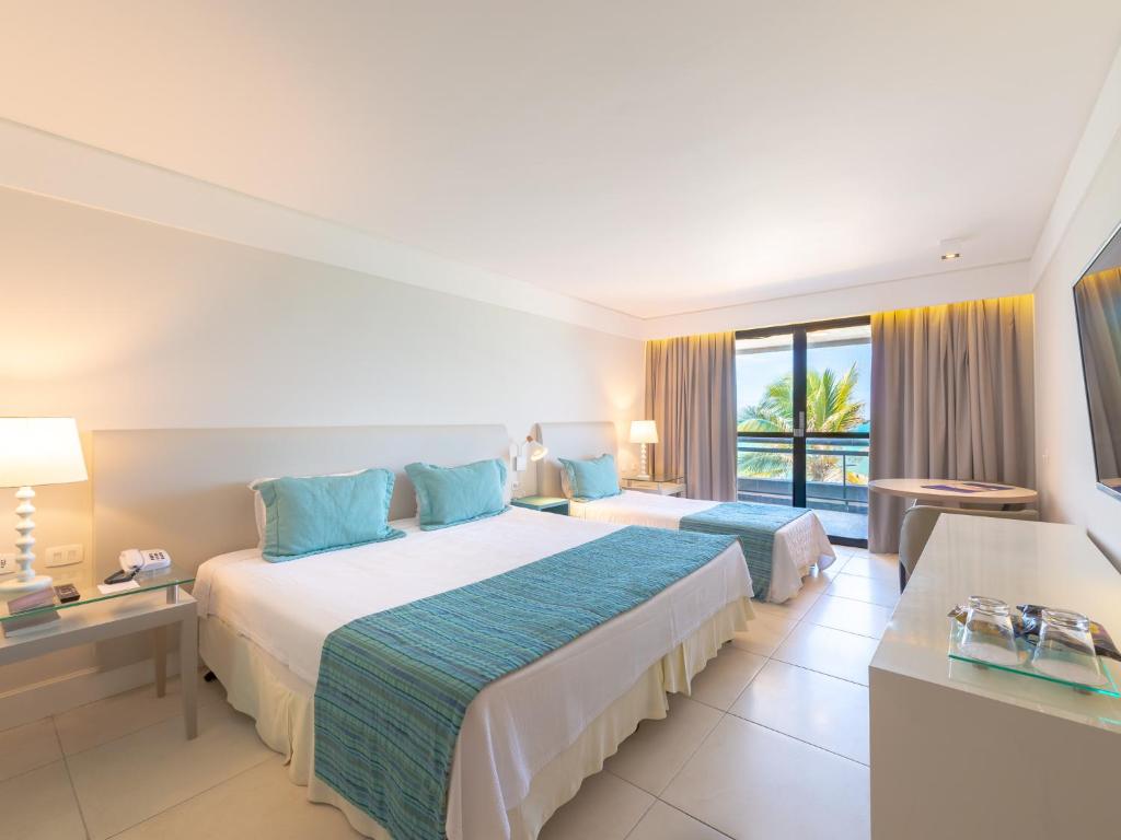 Quarto do Ocean Palace All Inclusive Premium em Natal com duas camas e varanda com vista para o mar