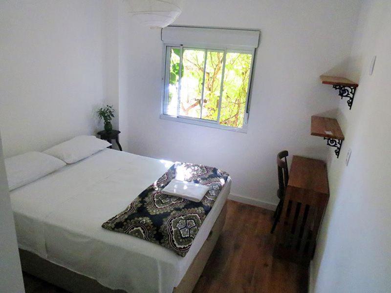 Quarto do Zen Hostel Brasil Hotel e Spa em São Paulo com cama de casal e janela com vista para árvores