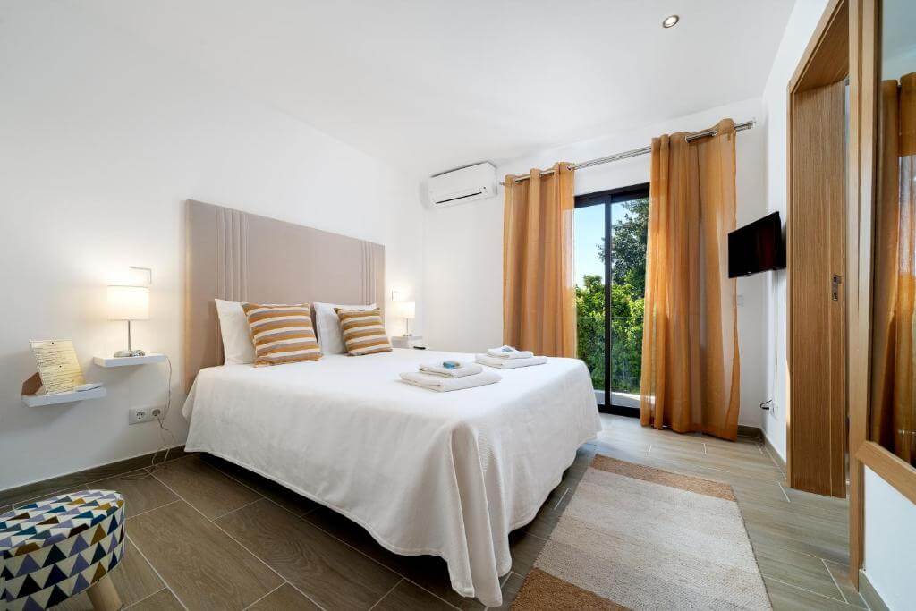 Quarto da Quinta das Andorinhas no Algarve com varanda e cortinas beges