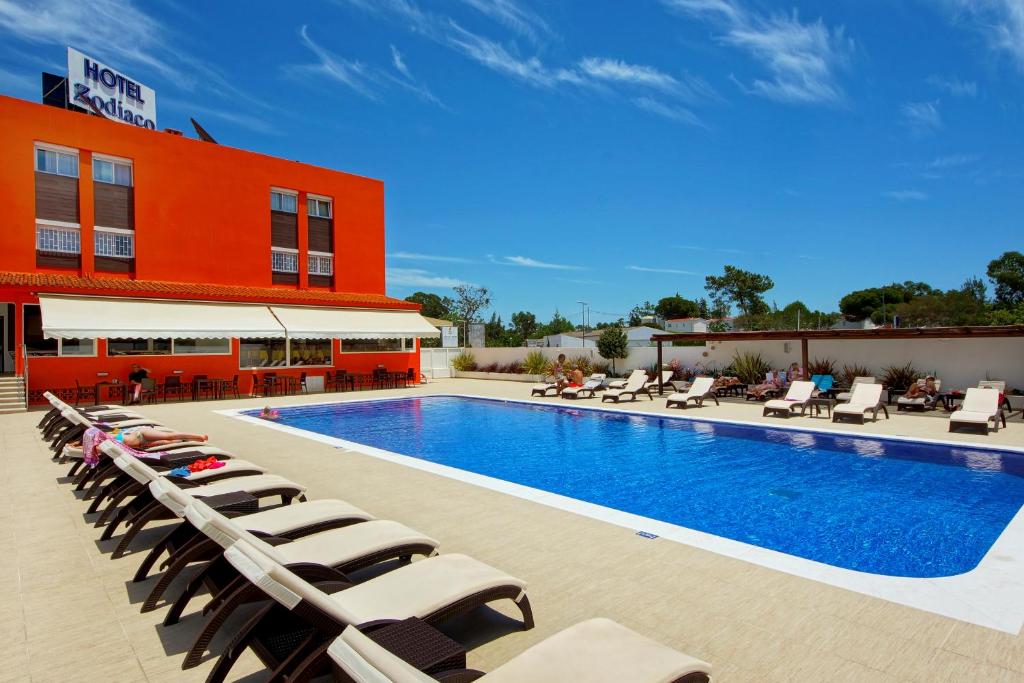 Piscina do Hotel Zodiaco no Algarve com espreguiçadeiras ao redor