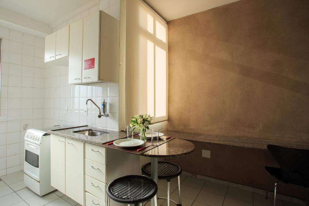 Cozinha compacta do Pampulha Flat em Belo Horizonte com bancada e mesa pequena