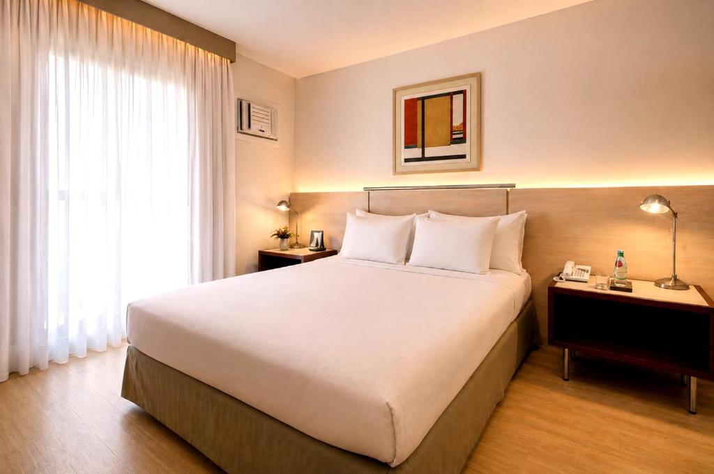 Quarto do Promenade Pancetti em Belo Horizonte com cama king size e iluminação quente