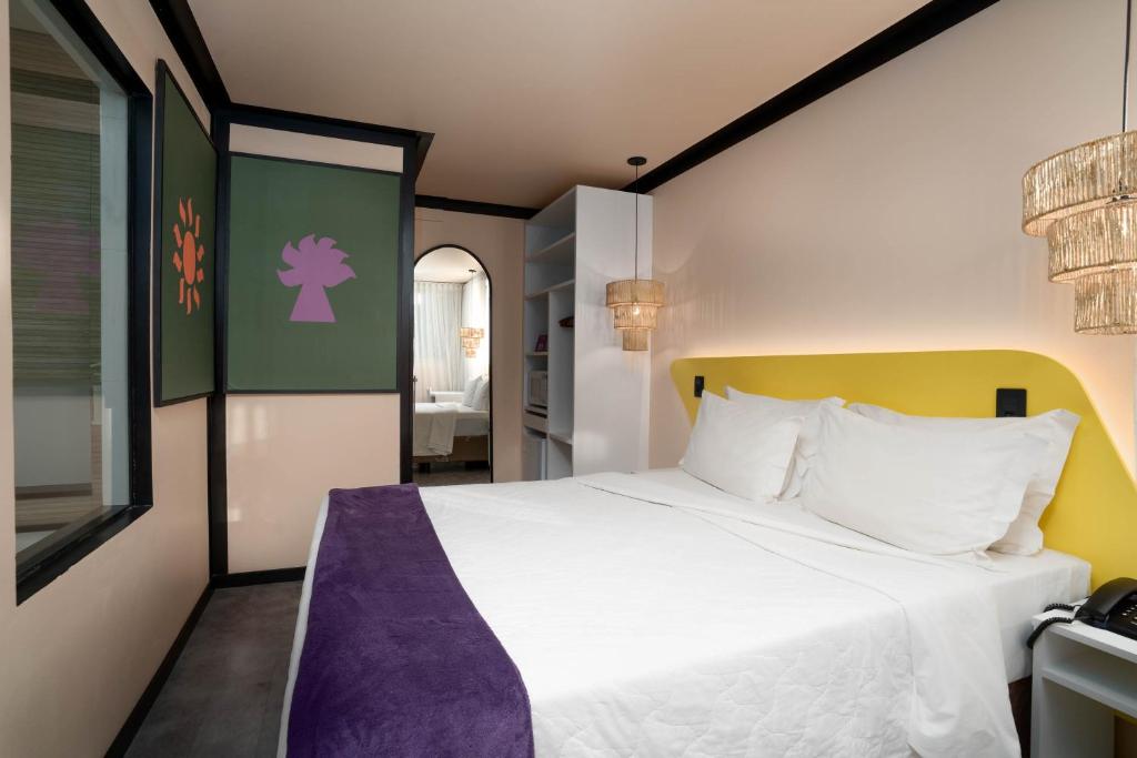 Quarto do Bossa Jurerê Hotel em Florianópolis com decoração contemporânea e detalhes coloridos