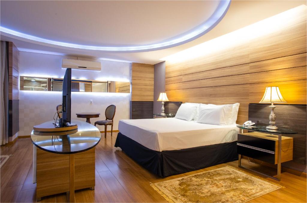 Quarto do Recanto Cataratas Thermas Resort e Convention com cama de casal e decoração em madeira