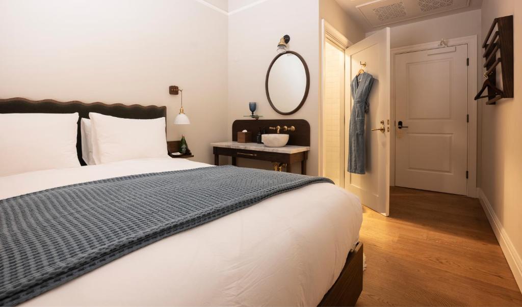 Quarto do Gjelina Hotel com cama de casal, penteadeira e espelho redondo