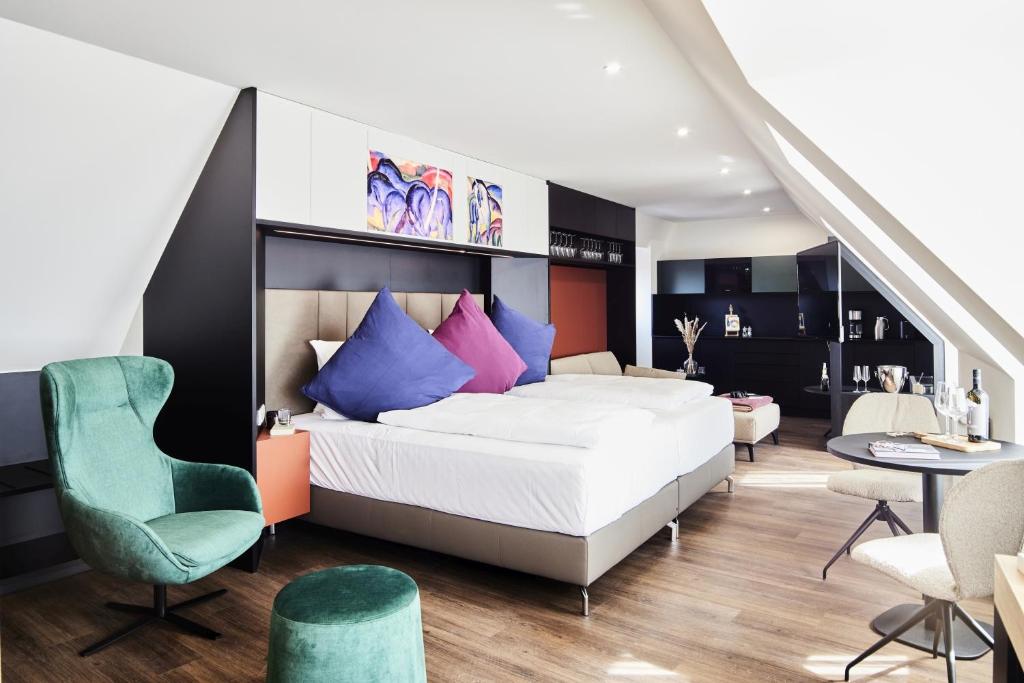 Suíte do Design und Kunsthotel München em Munique com poltrona verde e cama grande