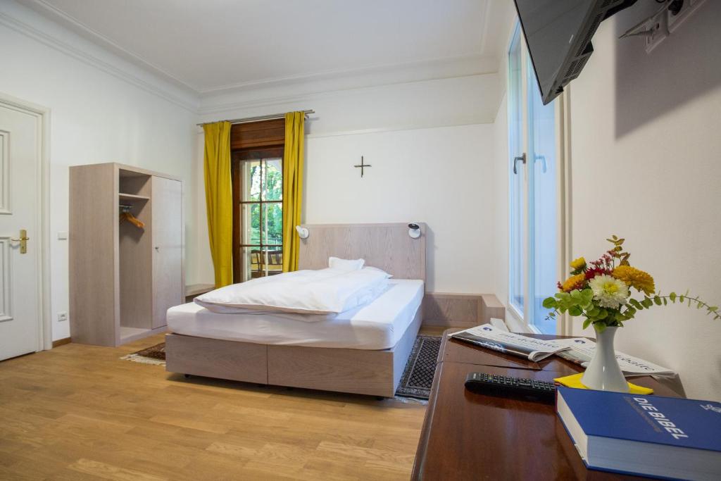 Quarto do Gästehaus der Katholischen Akademie in Bayern em Munique com cortinas amarelas