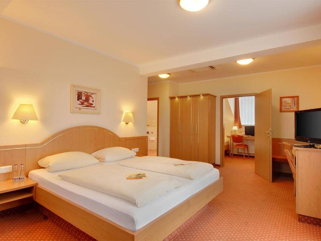 Quarto do Hotel Kriemhild am Hirschgarten em Munique com móveis de madeira clara