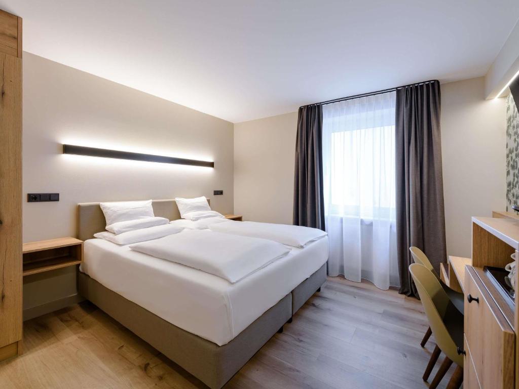 Quarto do Mercure Hotel München Altstadt em Munique com iluminação minimalista