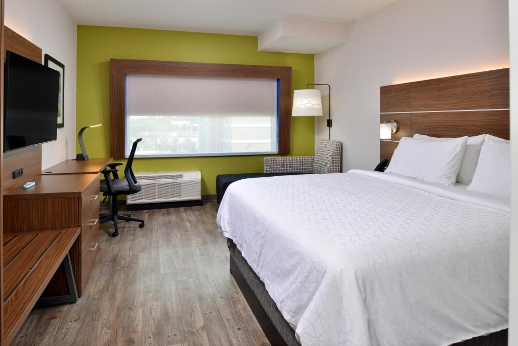 Quarto do Holiday Inn Express Orlando South Park by IHG com cama king, sofá e área de trabalho