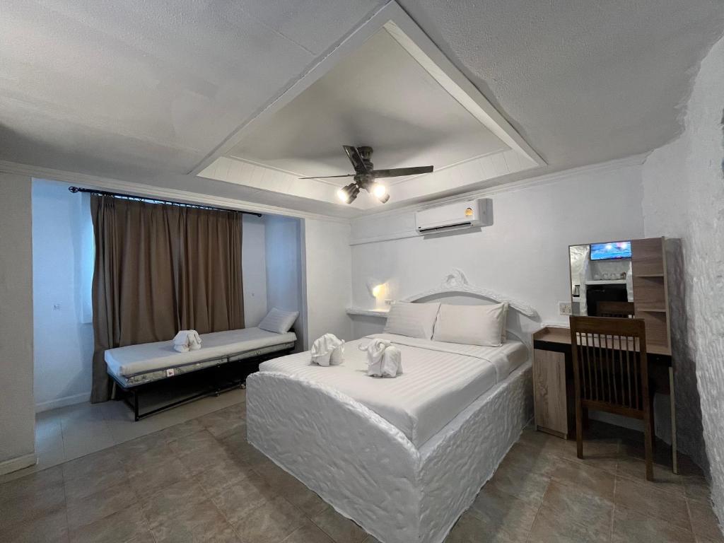 Quarto do Big Boys Bed and Burger em Phuket com cama branca e mesa de trabalho
