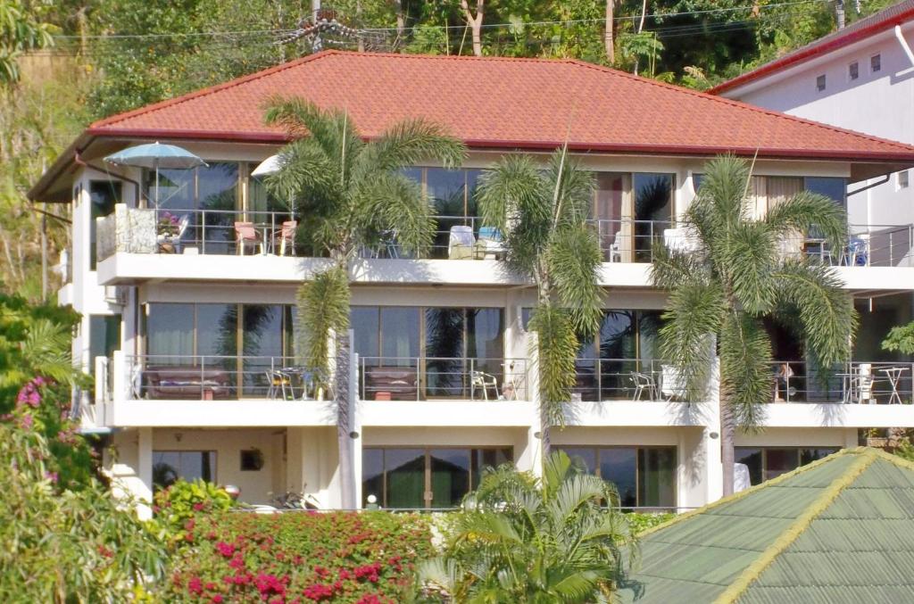 Fachada do Mountain Seaview Luxury Apartments em Phuket cercada por palmeiras