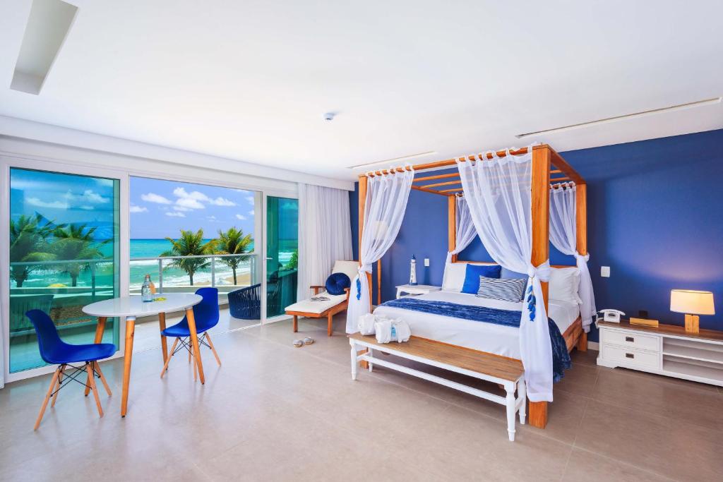 Suíte do Kembali Hotel em Porto de Galinhas com cama com dossel e vista para o mar