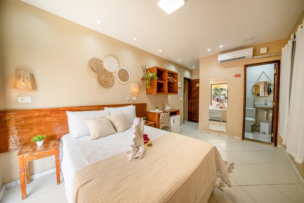 Quarto da Pousada Som dos Pássaros em Porto de Galinhas com cama de casal e decoração em madeira