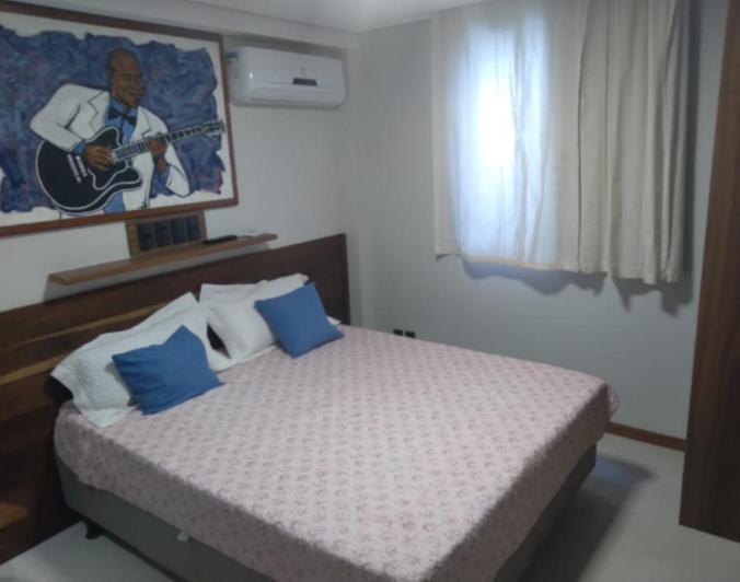 Quarto da Hospedaria D’Maria em Salvador com cama de casal e quadro decorativo na parede