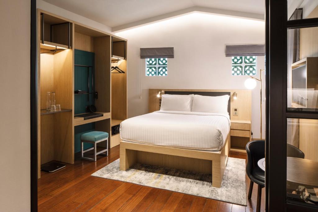 Quarto do KēSa House The Unlimited Collection em Singapura com móveis de madeira clara