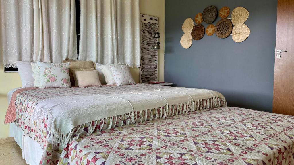 Quarto do Hostel Oxe em Trindade com cama grande e decoração colorida com almofadas e tapeçaria