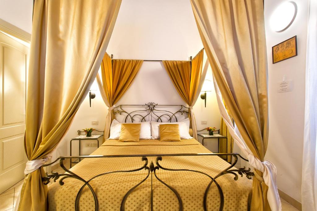 Quarto da Alla Vite Dorata em Veneza com cama de dossel e cortinas douradas
