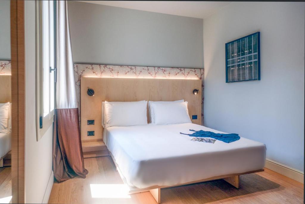 Quarto do Hotel Casa W em Veneza com cama de casal e decoração minimalista