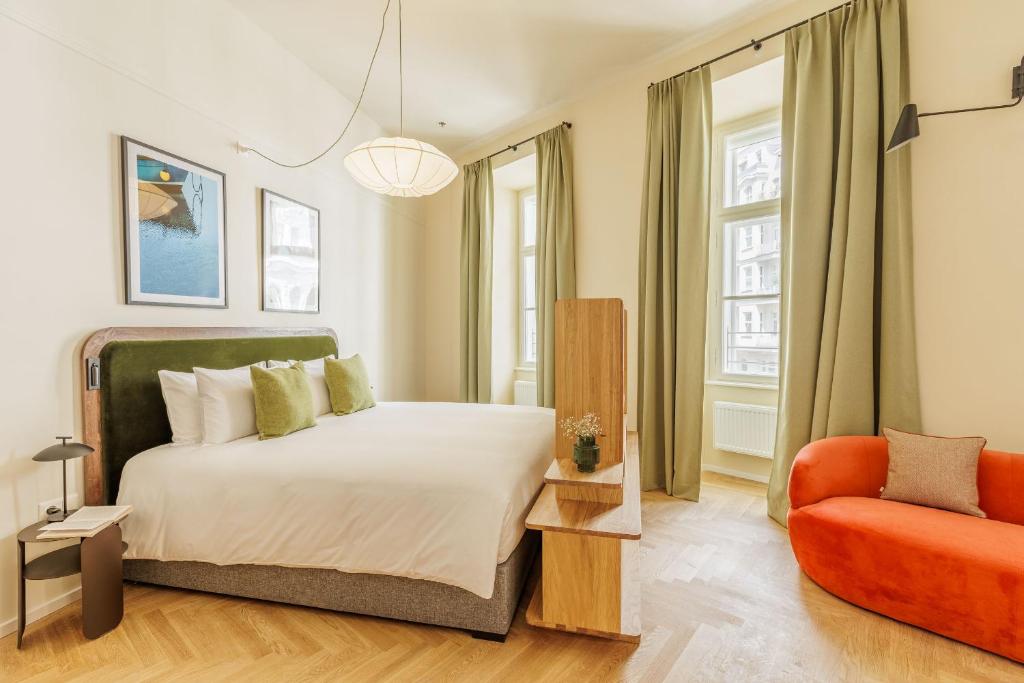 Quarto do Wilde Vienna Fleischmarkt em Viena com sofá vermelho e janelas altas