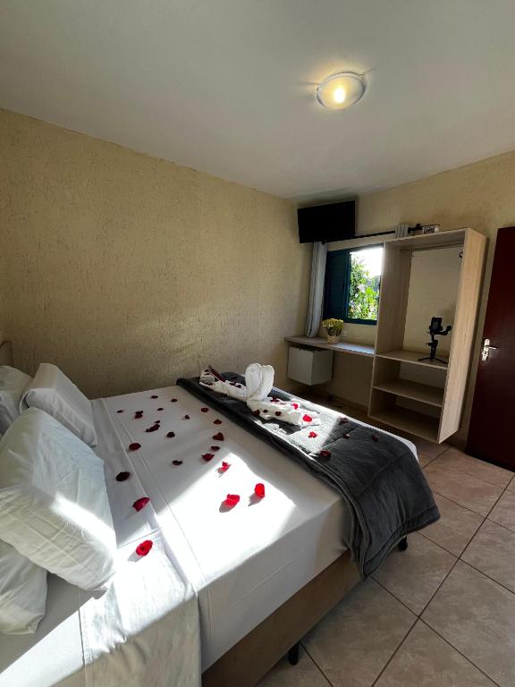 Quarto do Stallage Hotel em Águas de São Pedro com cama de casal decorada com pétalas e bancada com espelho