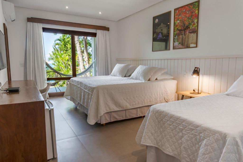 Quarto do Hotel Paraíso do Morro em Arraial d’Ajuda com duas camas e varanda com rede