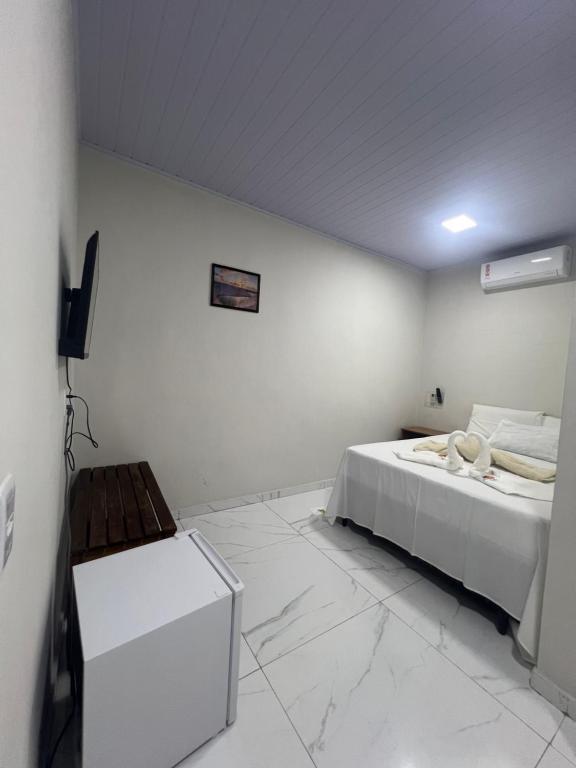 Quarto simples da Pousada Bangalô Dunas com cama de casal e piso branco