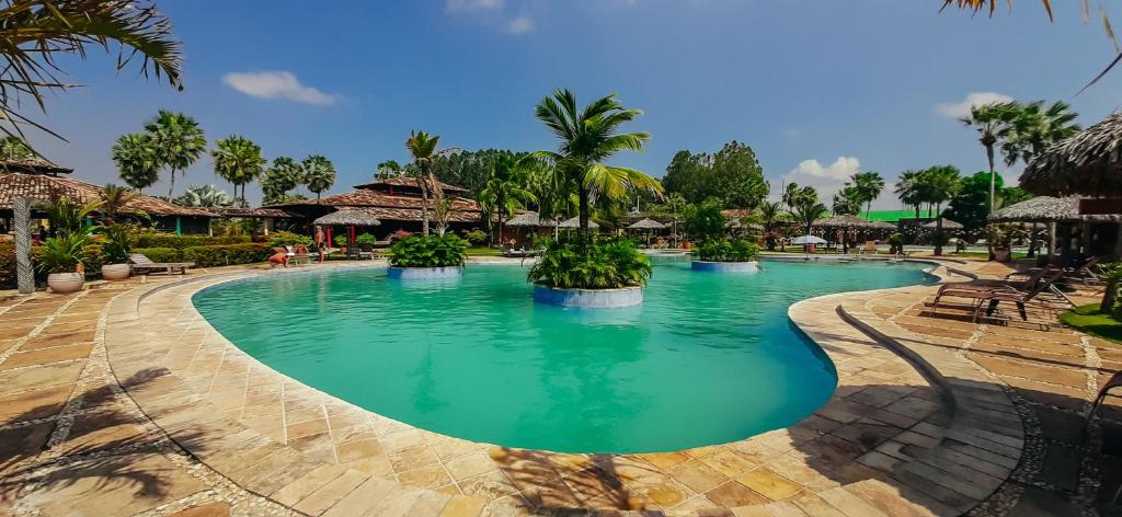 Piscina do Porto Preguiças Resort cercada por coqueiros e espreguiçadeiras