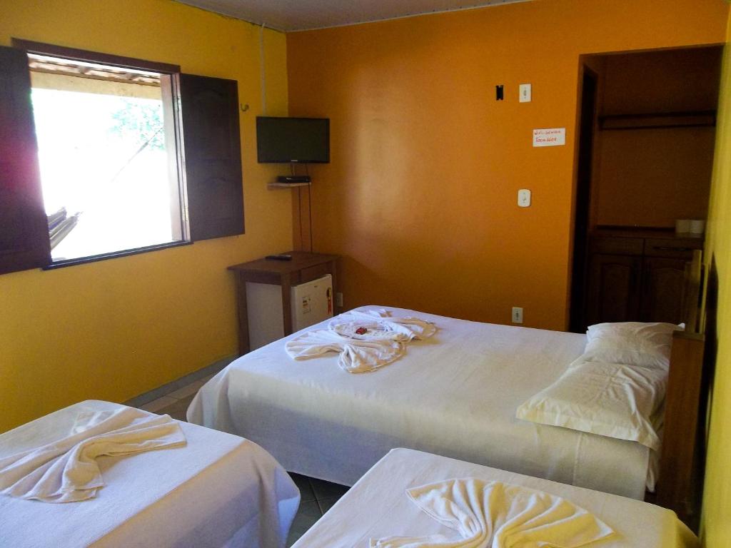 Quarto da Toca do Vaidoso com três camas e paredes amarelas