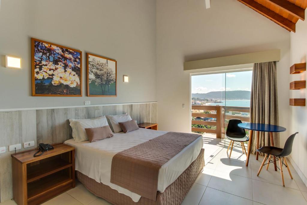 Quarto da Pousada do Arvoredo em Bombinhas com cama de casal, varanda e vista para o mar