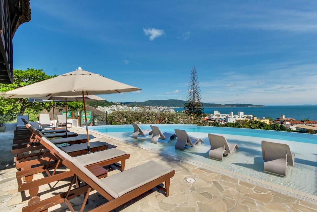 Piscina da Pousada do Arvoredo em Bombinhas com espreguiçadeiras e vista para o mar