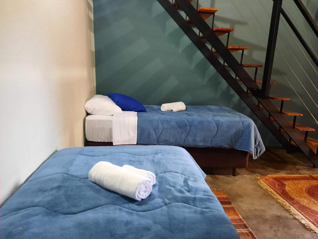Quarto da Pousada da Estação com duas camas de solteiro e escada interna