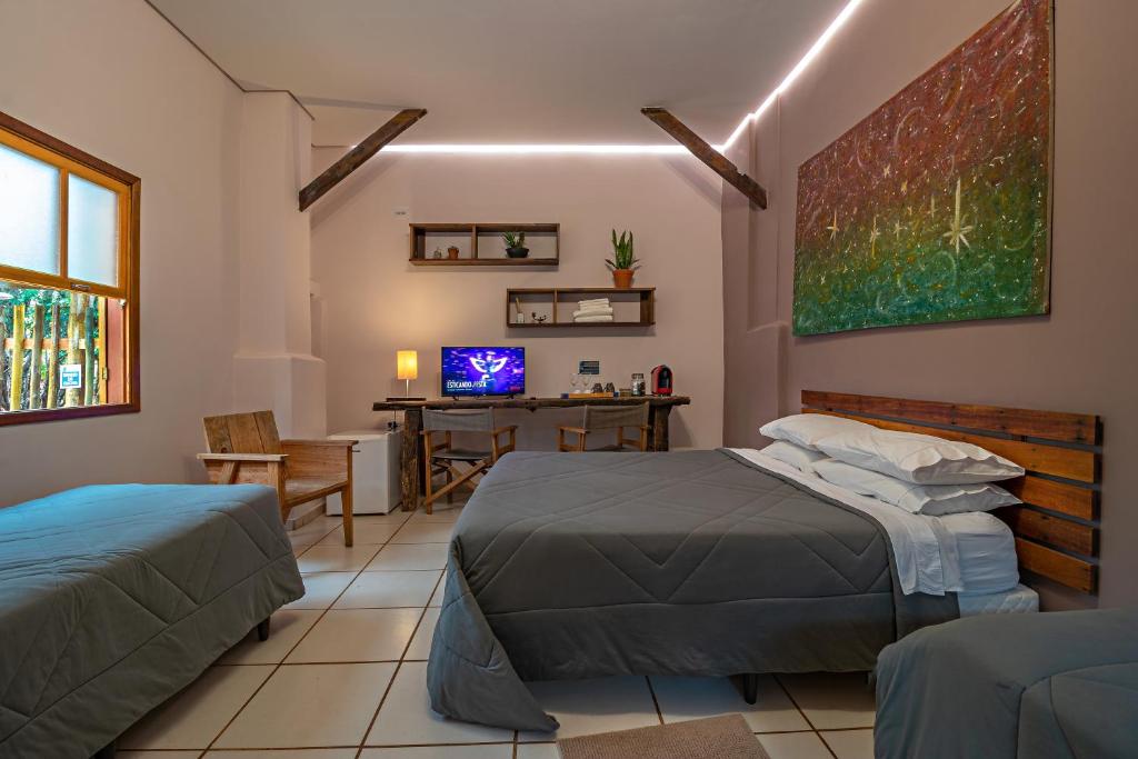 Quarto do Suítes no Quintal com cama de casal, cama de solteiro e decoração em tons de cinza